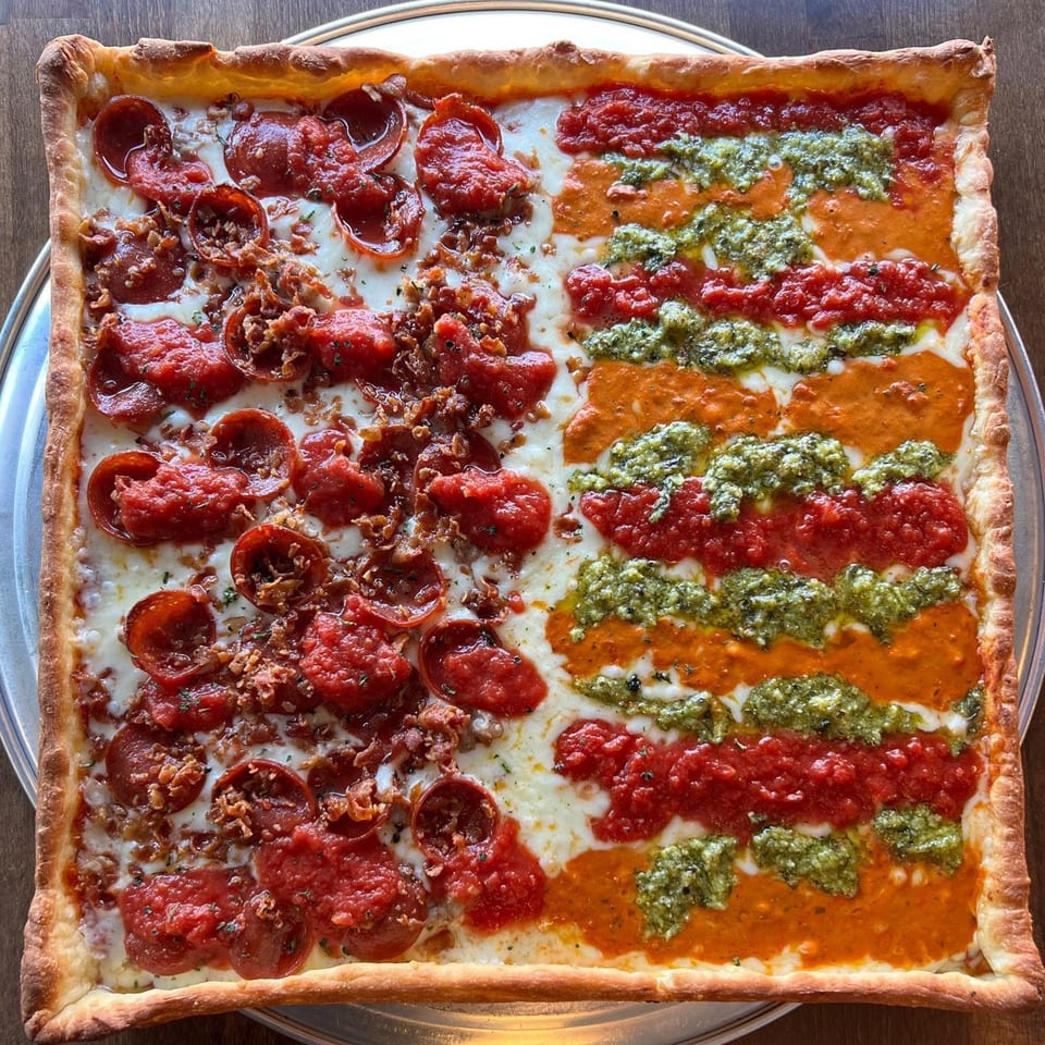 Square PEEL pizza with pepperoni and tomato sauce on one half, and pesto and vodka sauce on the other.